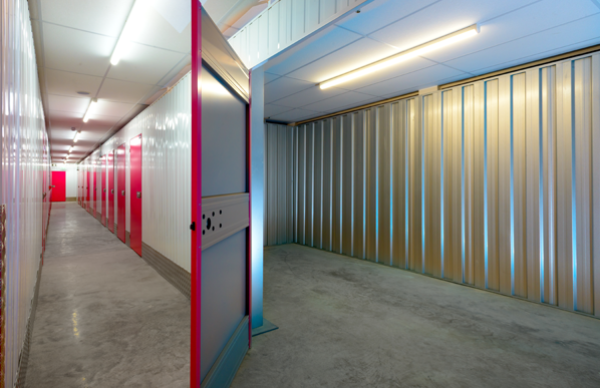 Large self storage unit shown with the door open with more rooms on corridor in background