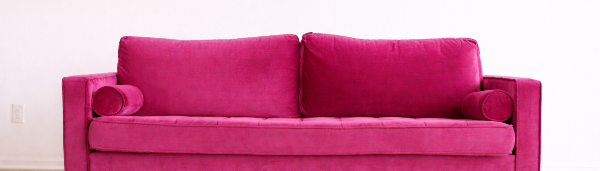 Vibrant magenta velvet sofa in minimalist room