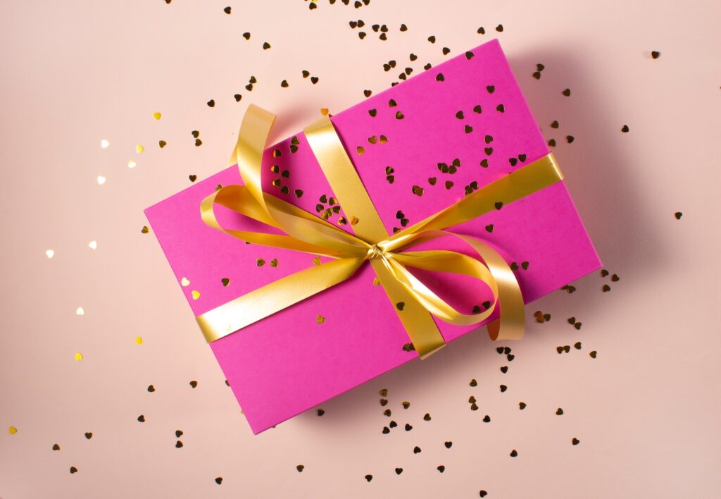 Pink present with gold ribbon and glitter